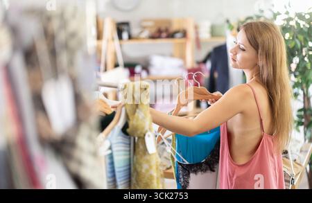 Die Frau wählt Kleidung aus der Sommerkollektion Stockfoto
