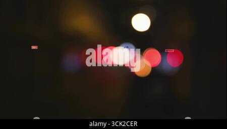 Anzeige von unscharfen Bokeh-Lichtern auf der städtischen Straße bei Nacht, mit roten weißen und orangen Lichtkugeln Stockfoto