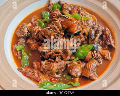 Frische Hähnchennuggets werden mit grüner Paprika auf dem Teller gegessen Stockfoto