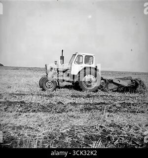 Ein sowjetischer Radtraktor MTZ-80 'Belarus' mit einem Pflug während des Herbstpflügens eines Feldes im Bezirk Sloviansk, ukrainische SSR, in den 1980er Jahren Das Archivfoto zeigt eine typische Szene der landwirtschaftlichen Arbeit auf einem Kolchos oder Sowchos. Dieser Rahmen ist ein Symbol für die Mechanisierung der sowjetischen Landwirtschaft, den „Kampf um die Ernte“ und die kreative Arbeit auf dem fruchtbaren ukrainischen Chernozem in der späten UdSSR-Ära, die die Weiten der Donbass-Felder zeigt Stockfoto