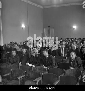 Ein Archivfoto des Publikums während einer Partei oder gewerkschaftskonferenz in Sloviansk, Ukrainische SSR, im Februar 1975. In der ersten Reihe sitzt unter den Delegierten – Arbeiter und Parteiaktivisten – eine Frau in der Uniform eines sowjetischen Militsiya-Kapitäns, was die Beteiligung aller staatlichen Strukturen am öffentlichen Leben betont. Dieses Foto ist ein dokumentarischer Beweis für die Einheit des Verwaltungssystems während der Stagnation und zeigt die typische Zusammensetzung der Teilnehmer an einem formellen Stadtereignis während Friedenszeiten Stockfoto