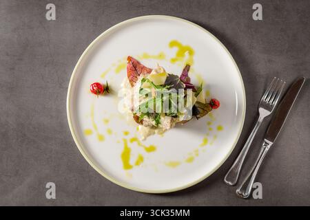 Gegrilltes Hühnchen mit Pilzen und Sahnesauce auf einem dunklen Steintisch Stockfoto