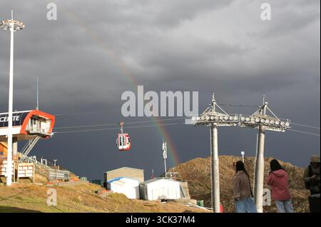 Altay, Chinas Autonome Region Xinjiang Uygur. September 2025. Touristen fotografieren am 9. September 2025 einen Regenbogen auf einem Berg im Jiangjunshan International Ski Resort in Altay, der autonomen Region Xinjiang Uygur im Nordwesten Chinas. Die Region Altay von Xinjiang, in der jedes Jahr bis zu 210 Tage Schnee fällt, ist ein ideales Ziel für Skiliebhaber. Die Region hat sich in den letzten Jahren bemüht, neue Attraktionen und Programme zu entwickeln, um die Lücke ohne Schneefall zu schließen, damit sich Touristen das ganze Jahr über hier Vergnügen können. Quelle: Cheng Li/Xinhua/Alamy Live News Stockfoto