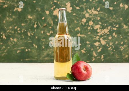 Flasche frischen Apfelwein und Obst auf weißem Tisch Stockfoto