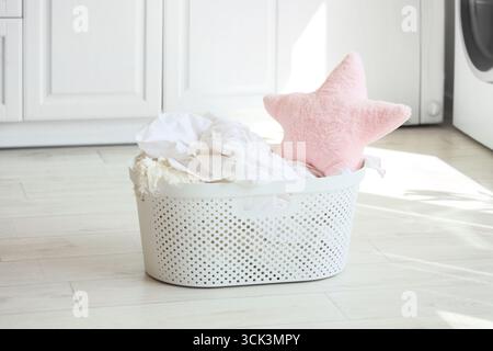 Wäschekorb mit Sternenkissen auf dem Boden im Zimmer Stockfoto
