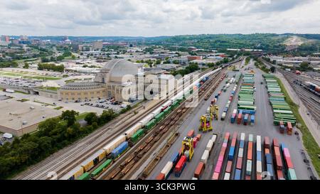 Cincinnati, USA - 22. August 2025: Aus der Vogelperspektive des ikonischen Cincinnati Union Terminals, dessen Art-Deco-Architektur den lebhaften Farben der gestapelten Schiffscontainer gegenübersteht. Stockfoto