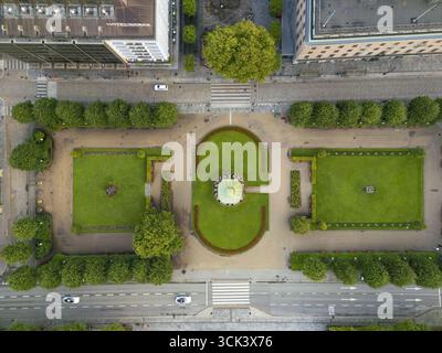 Blick aus der Vogelperspektive auf einen formellen Garten mit gepflegten Rasenflächen und symmetrischen Hecken, eine grüne Oase inmitten der urbanen Landschaft, im Kontrast zu den umliegenden Gebäuden, Bergen, Vestland, Norwegen. Stockfoto