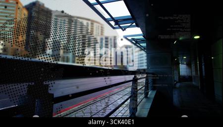 Rasante Pendlerzüge, die über modernen städtischen Bahnsteig verschwimmen, mit perforiertem Sicherheitsschild Stockfoto