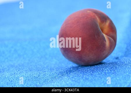 Frischer Pfirsich auf funkelndem blauem Hintergrund Stockfoto