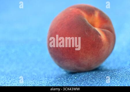 Frischer Pfirsich auf funkelndem blauem Hintergrund Stockfoto