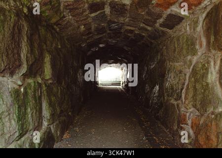 Ein mittelalterlicher Tunnel mit hellem Licht am Ende des Tunnels. Stockfoto