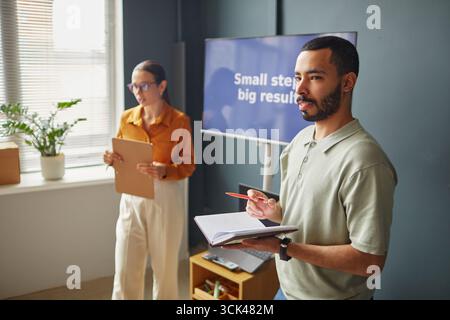 Junge Erwachsene kaukasische Frau und junger Erwachsener Schwarzer Mann unterrichten Sprachunterricht Stockfoto