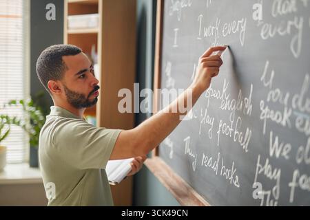Junger Erwachsener Schwarzer Mann, der Englisch-Grammatik an der Sprachschule unterrichtet Stockfoto