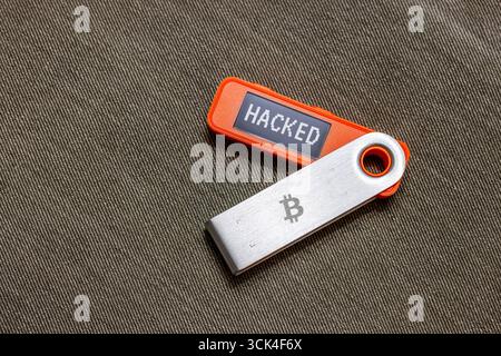 Orange Hardware Bitcoin Cold Wallet mit Nachricht auf dem Bildschirm gehackt Stockfoto