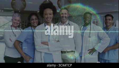 Posierendes Team im Krankenhaus mit Mänteln, Stethoskopen, die holographische Globus-Daten-Overlay projizieren Stockfoto