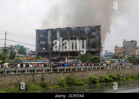 Kathmandu, Nepal. September 2025. Die Menschen beobachten den Bhat Bhateni Supermarkt, Nepals größtes Kaufhaus, das am 9. September von den Demonstranten in der gewalttätigen Demonstration in Brand gesetzt wurde. Quelle: SOPA Images Limited/Alamy Live News Stockfoto