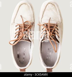 Ein Paar legere Schuhe mit einem Obermaterial aus hellem Wildleder und braunen Schnürsenkeln, die für den Alltag geeignet sind. Stockfoto