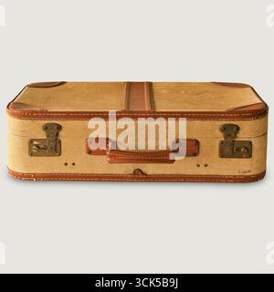 Ein Vintage-Koffer mit abgenutzter Außenseite und Lederakzenten, geeignet für Reisen und Aufbewahrung. Stockfoto