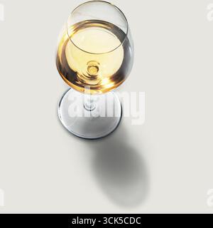 Ein Blick von oben auf ein mit einer goldenen Flüssigkeit gefülltes Weinglas mit elegantem Design und reflektierender Oberfläche. Stockfoto