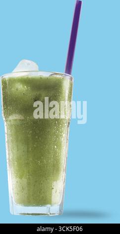 Ein erfrischendes grünes Getränk, das in einem hohen Glas mit Eis und violettem Strohhalm serviert wird. Stockfoto