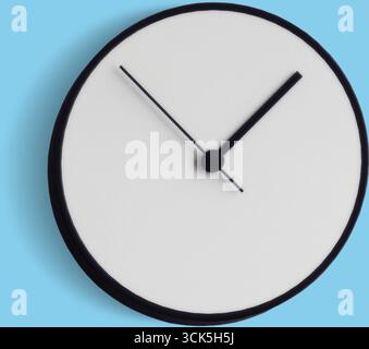 Eine einfache Wanduhr mit minimalistischem Design, die die Uhrzeit anzeigt. Stockfoto