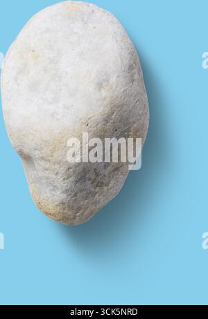 Ein glatter, abgerundeter Stein mit einer hellen Farbe, der natürliche Textur und Form zeigt. Stockfoto