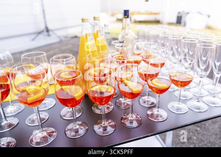 Viele Cocktailgläser mit orangefarbenem Getränk auf einem Tisch bei einer Outdoor-Party, Bodensee, Deutschland Stockfoto