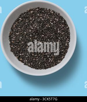 Eine Schüssel gefüllt mit schwarzen Chiasamen, die ihre kleine Größe und Textur zeigen. Stockfoto