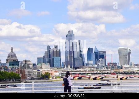 London, Großbritannien. August 2025. Eine Person auf der Waterloo Bridge macht Fotos von der Skyline der City of London. Quelle: Vuk Valcic/Alamy Live News Stockfoto