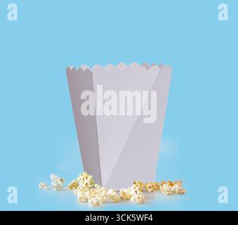 Ein einfacher weißer Popcorn-Behälter mit verstreutem Popcorn, der in der Regel für Snacks in Kinos verwendet wird. Stockfoto