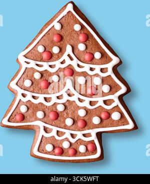 Ein festlicher Lebkuchenkeks in Form eines Weihnachtsbaums, verziert mit bunten Glasur und Süßigkeiten. Stockfoto