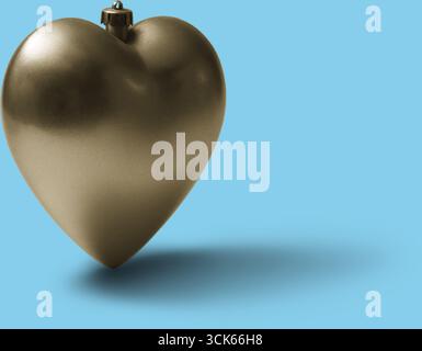Ein glänzend goldenes herzförmiges Ornament, das Liebe und Zuneigung symbolisiert, möglicherweise als Dekoration oder als Geschenk. Stockfoto