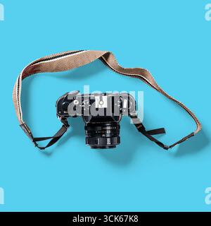 Eine Vintage-Kamera mit Riemen, die ihr Design und ihre Funktionalität für Fotografen präsentiert. Stockfoto