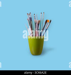 Eine Sammlung verschiedener Pinsel in einem grünen Halter, ideal für künstlerische Projekte und kreative Aktivitäten. Stockfoto