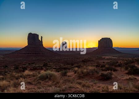 Der Sonnenaufgang hinter den Mittens und Merrick Butte im Monument Valley, USA Stockfoto