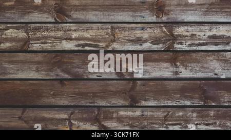 Aus nächster Nähe sehen Sie eine rustikale Holzwand mit unterschiedlichen Farben und Texturen. Stockfoto