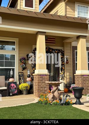 Vorstadthaus mit Kürbissen, Girlanden und Halloween-Ornamenten, darunter „Trick or Treat“-Schilder und verspielte Gartendetails. Stockfoto