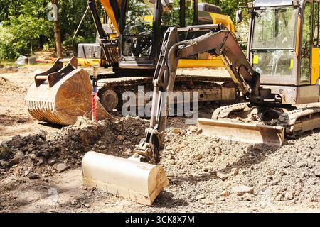 Bagger auf der Baustelle. Schwere Maschinen beim Graben von Boden. Industrielle Erdbewegungsgeräte für den Straßenbau und die Infrastrukturentwicklung Stockfoto