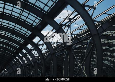 Moderne Dachkonstruktion aus Stahl und Glas. Architektonische Details der gewölbten transparenten Decke. Stadtbau mit Industriemuster. Stockfoto