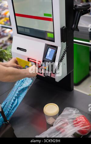 Eine Frau scannt Artikel an einer Selbstkasse. Stockfoto