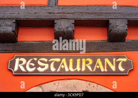 Vintage-Restaurantschild an einer rustikalen Holzbalkenfassade in Ribeauville, Frankreich. Stockfoto