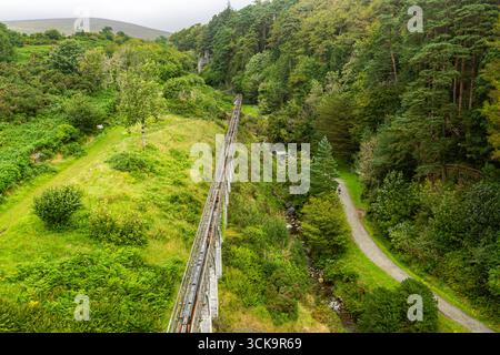 Laxey, Isle of man 08,05,2023 lange Holzbrücke überspannt ein Tal mit einem üppig grünen Wald auf beiden Seiten. Die Brücke ist von Bäumen und Gras umgeben. Stockfoto