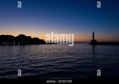 Venezianischer Leuchtturm und Hafen von Chania in der Dämmerung, Kreta, Griechenland. Malerischer Blick auf den alten venezianischen Hafen bei Sonnenuntergang mit ruhigem Meer und farbenfrohen s Stockfoto