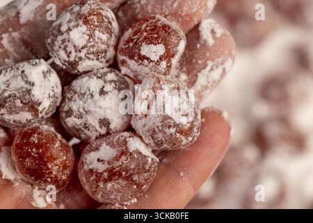 Getrockneter Kumquat und weißer Puderzucker, süße getrocknete Orangenkumquatfrüchte in Weißzucker Stockfoto