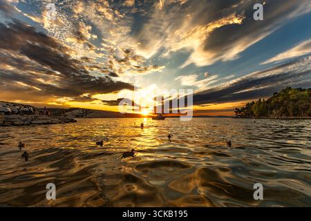 Dramatischer Himmel, Sonnenuntergang in Lopar auf der Insel Rab, orange, rote, blutrote Wolken über der Adria Stockfoto