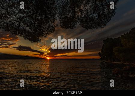 Dramatischer Himmel, Sonnenuntergang in Lopar auf der Insel Rab, orange, rote, blutrote Wolken über der Adria Stockfoto