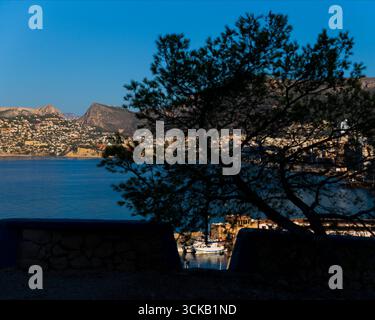 Blick auf den Hafen von Calpe, Schwerpunkt im Mittelriss und Hintergrund, mit gerahmten Fischerbooten Stockfoto