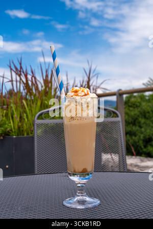 Eiskaffee mit Schlagsahne und Karamell in einem hohen Glas. Stockfoto