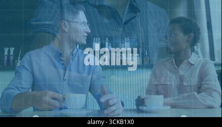 Sprechender Mann und Frau, der weiße Keramikbecher und Untertassen auf dem Tisch im Café hält Stockfoto