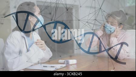 Arzt in Mantel und Maske, der über Kopfschmerzen des Patienten im Untersuchungsraum spricht, Infrarot-Thermometer, Kopierraum Stockfoto